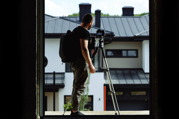 An interior photographer on a construction site takes a photo from a tripod for the website.