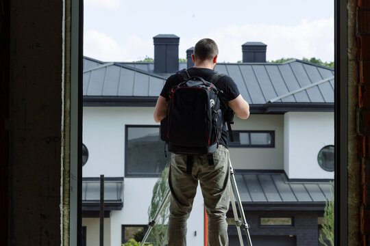 An interior photographer on a construction site takes a photo from a tripod for the website.