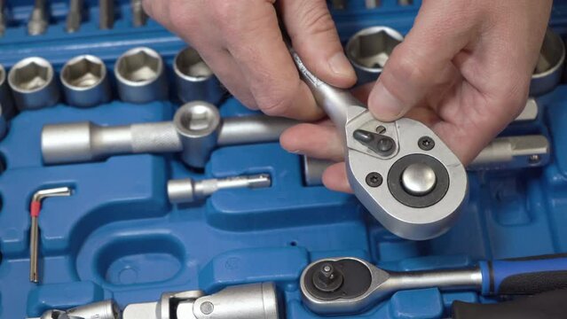 ratchet key in hands,blue box with tools for car repair