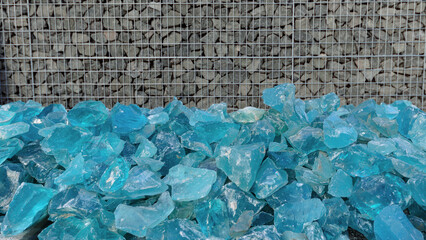 Aquamarine decorative crystal stone on gabion background.