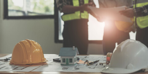 Civil engineer teams meeting working together wear worker helmets hardhat on construction site in modern city. Foreman industry project manager engineer teamwork. Asian industry professional team.