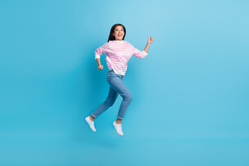 Fototapeta na wymiar Full length photo of excited pretty girl dressed pink pullover jumping high running fast isolated blue color background