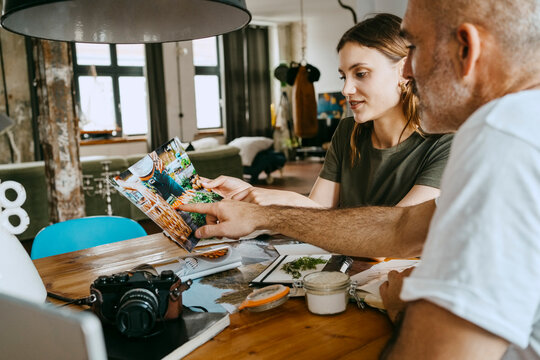 Male and female business colleagues discusing over photograph in studio