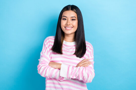 Photo of shiny confident young lady wear striped sweater arms folded smiling isolated blue color background