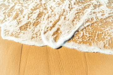 Close-up of a beach with a calm transparent wave. Romantic sea coast with golden sand.