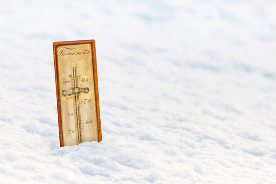 Ancient ornamental thermometer in a white snow landscape