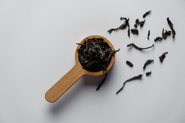 Black tea in a scoop on a white background. The Close-up shot. High quality photo