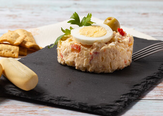 Close-up Russian salad on black slate plate