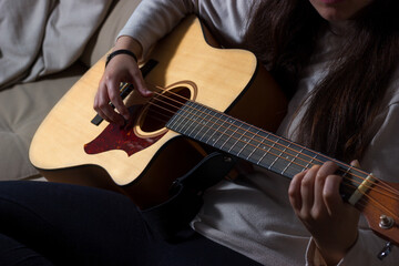 Girl playing an acoustic guitar in a relaxed atmosphere