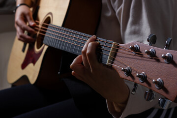 Girl playing an acoustic guitar in a relaxed atmosphere