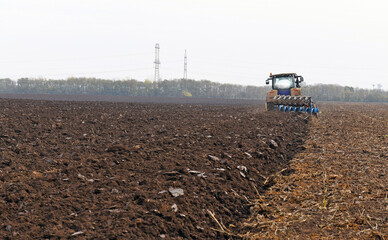 Fototapeta premium Tractor with plow on the agricultural field