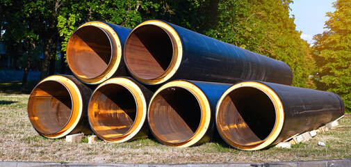 Large metal pipes covered thermal plastic sheath at construction site. Insulated pipe, pipeline improvement. Pipeline for supplying hot water, heating to residential area, replacement and renovation