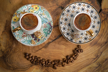 Two Turkish coffee cups on a wooden background. Coffee cups and coffee beans in the shape of a smiley face.