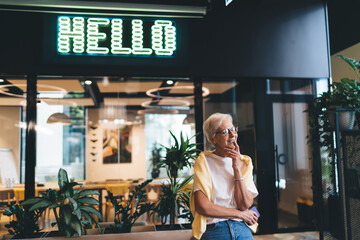 Thoughtful adult woman smiling and daydreaming
