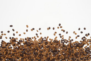 Fototapeta premium Coffee beans on a white background, some well-roasted, some under-roasted. Empty top, suitable for writing
