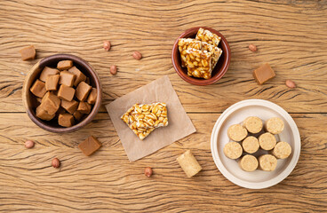 Typical brazilian candies over wooden table. Doce de leite or dulce de leche, pe de moleque and pacoca