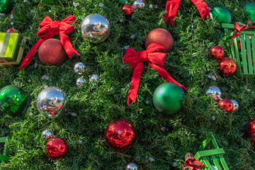 Close up of a decorated Christmas tree with green, silver, and red balls. - Powered by Adobe