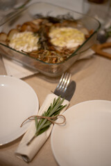 Vintage silverware with a twig of rosemary and empty tag on rustic wooden background