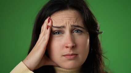 Tired fatigued woman 20s with migraine headache posing isolated on green screen background studio. Closeup people lifestyle concept. Put hands on head temples