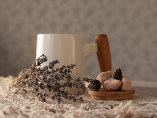 Still life. White cup with wooden handle, small cones and dry lavender