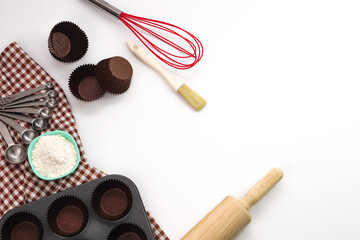 Top view kitchenware wooden rolling pin, wooden spatula and egg beater on white background. Materials or kitchen equipment for bakery.