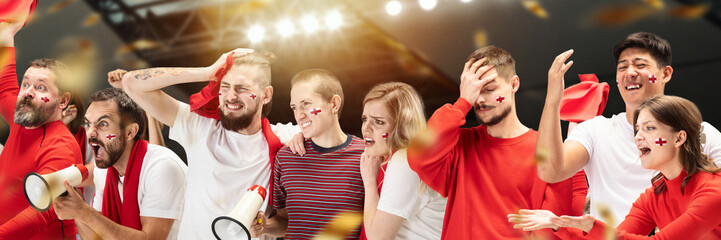 Group of emotive young people, football, soccer fans attending competition at the stadium. Despair....