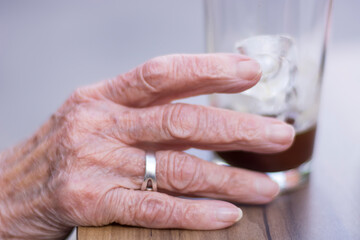 Naklejka premium Old person holding a glass of water
