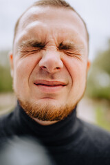 Close-up portrait of a bearded man's face outdoors.