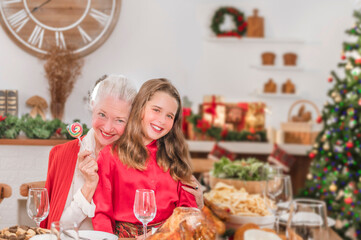 On Christmas Eve, the grandmother gave their grandchildren a candy while giving her a hug.