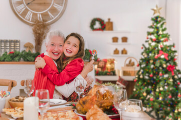 Grandchildren gave their grandmother a gift while giving her hug on Christmas Eve