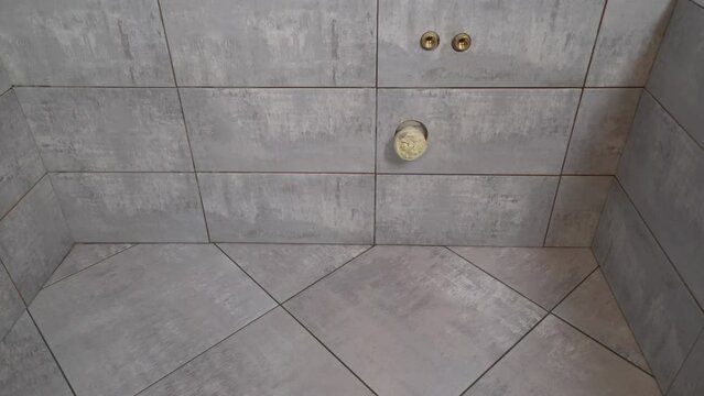 Materials for home renovation. Finishing work in the house, laying tiles on the floor. Ceramic tiles on the floor and on the wall in the bathroom. beige ceramic tiles on the wall.