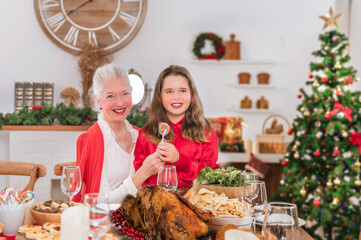 On Christmas Eve, the grandmother gave their grandchildren a candy while giving her a hug.