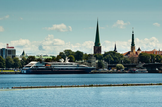 RIGA, LATVIA - AUGUST 2, 2022: panorama of the city of Riga, pictured old town, river, yachts and blue sky with clouds