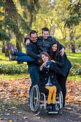 Woman in a wheelchair taking selfie with friends in a park