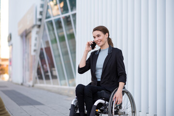 Businesswoman in a wheelchair talking on mobile phone
