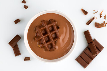Chocolate pudding in a bowl top view isolated on white