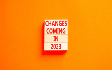 Changes coming in 2023 symbol. Concept word Changes coming in 2023 on wooden blocks. Beautiful orange table orange background. Business and changes coming in 2023 concept. Copy space.