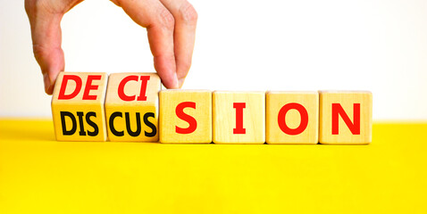 Discussion and decision symbol. Concept word Discussion and Decision on wooden cubes. Businessman hand. Beautiful yellow table white background. Business discussion and decision concept. Copy space.