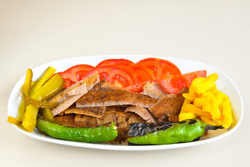 Turkish and Arabic Traditional Ramadan doner kebab with tasty tomato sauce and rice or turkish pilav in white plate on wood table background. ( Pilav ustu doner)