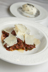 marinated fish tar tar with parmesan cheese on a white plate