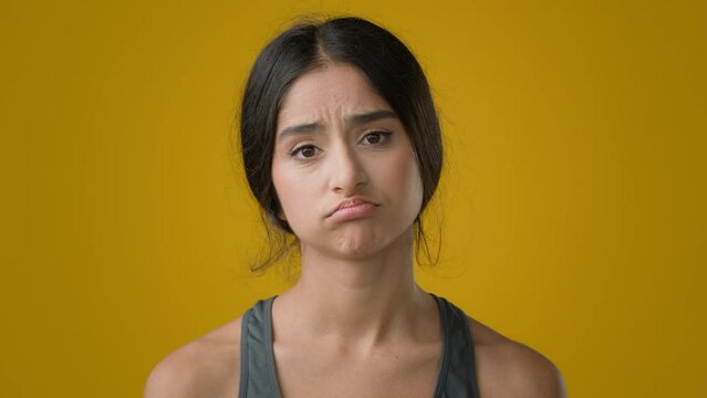 Sad upset worried Indian woman girl in yellow studio with measuring tape dissatisfied with body measure unhappy weight size shape fitness result waist diet bulimia anorexia unhealthy depression