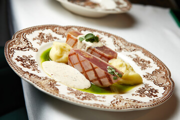grilled tuna steak with mashed potatoes and gravy on a beautiful plate