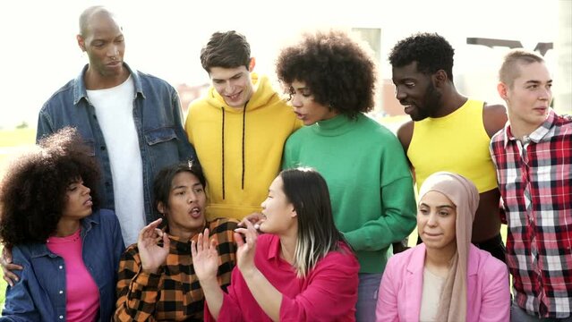 Group of portraits of happy young people. Diverse millennial friends relaxing together sitting on the city street. Friendship and youth lifestyle. diverse lgbt people