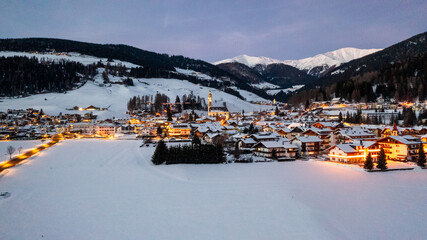 winter landscape, Dobbiaco Toblach, Bolzano, Italy. Aerial drone shot in january, Aerial view of beautiful alpin mountain town, christmas time , city with lights