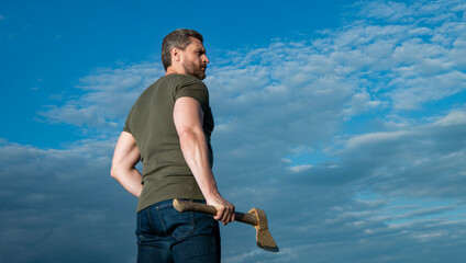 man with axe. woodcutter man hold ax. brutal man on sky background