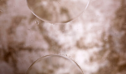 abstract background of brown oil balls in water and bubbles