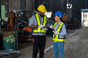 Male and female worker wear safety uniform working and discuss of work in the industry factory