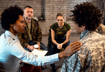 Group of diverse veterans talking during PTSD support group.