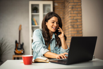 Beautiful pregnant woman working on laptop. Young businesswoman talking to the phone..