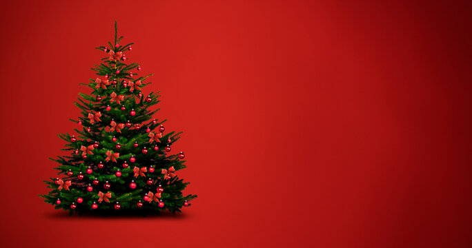 Weihnachtbaum mit Roten Kugeln und Schleifen vor rotem Hintegrund